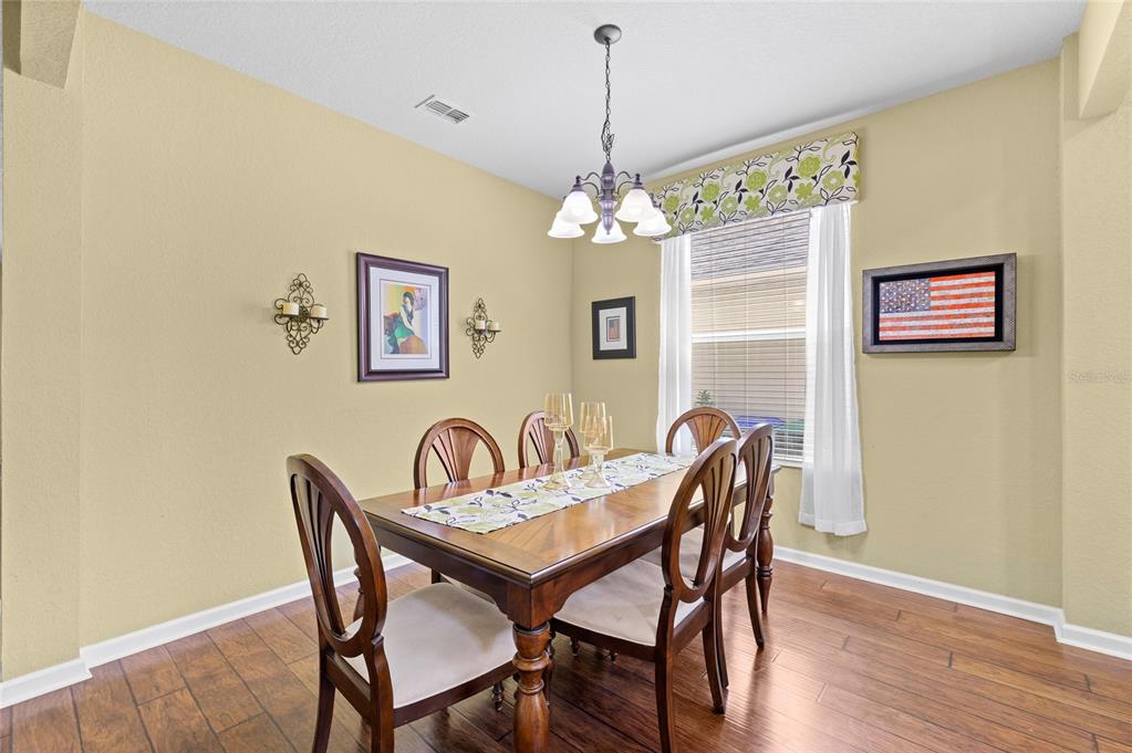 13243 Charfield Street Windermere, FL 34786 - Photo 16 of 39 a dining room with furniture a chandelier and wooden floor