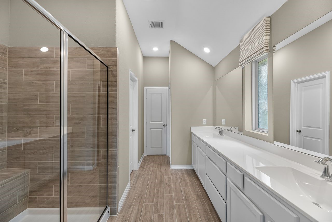21714 Grayson Highlands Way Porter, TX 77365 - Photo 15 of 27 a bathroom with a double vanity sink a toilet and a mirror