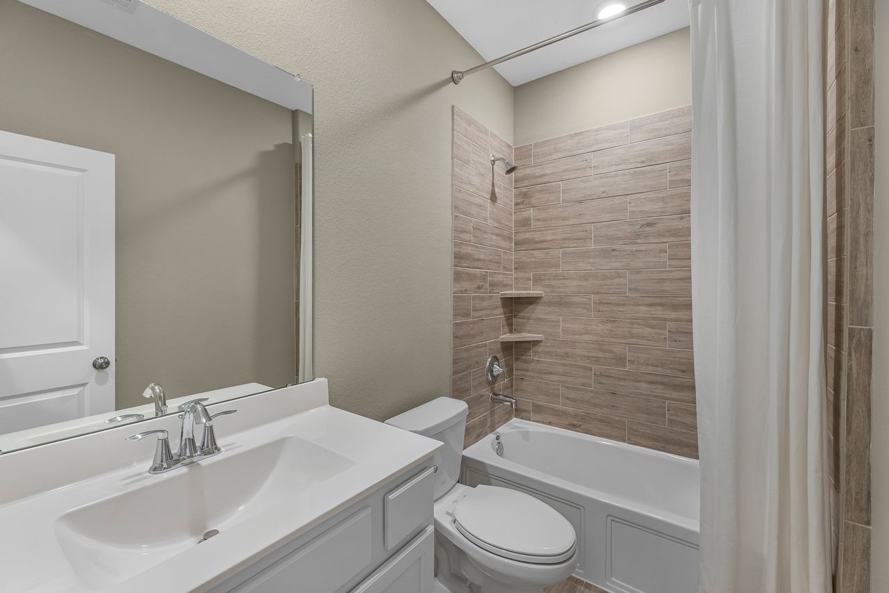 21714 Grayson Highlands Way Porter, TX 77365 - Photo 23 of 27 a bathroom with a bathtub shower sink vanity mirror and toilet