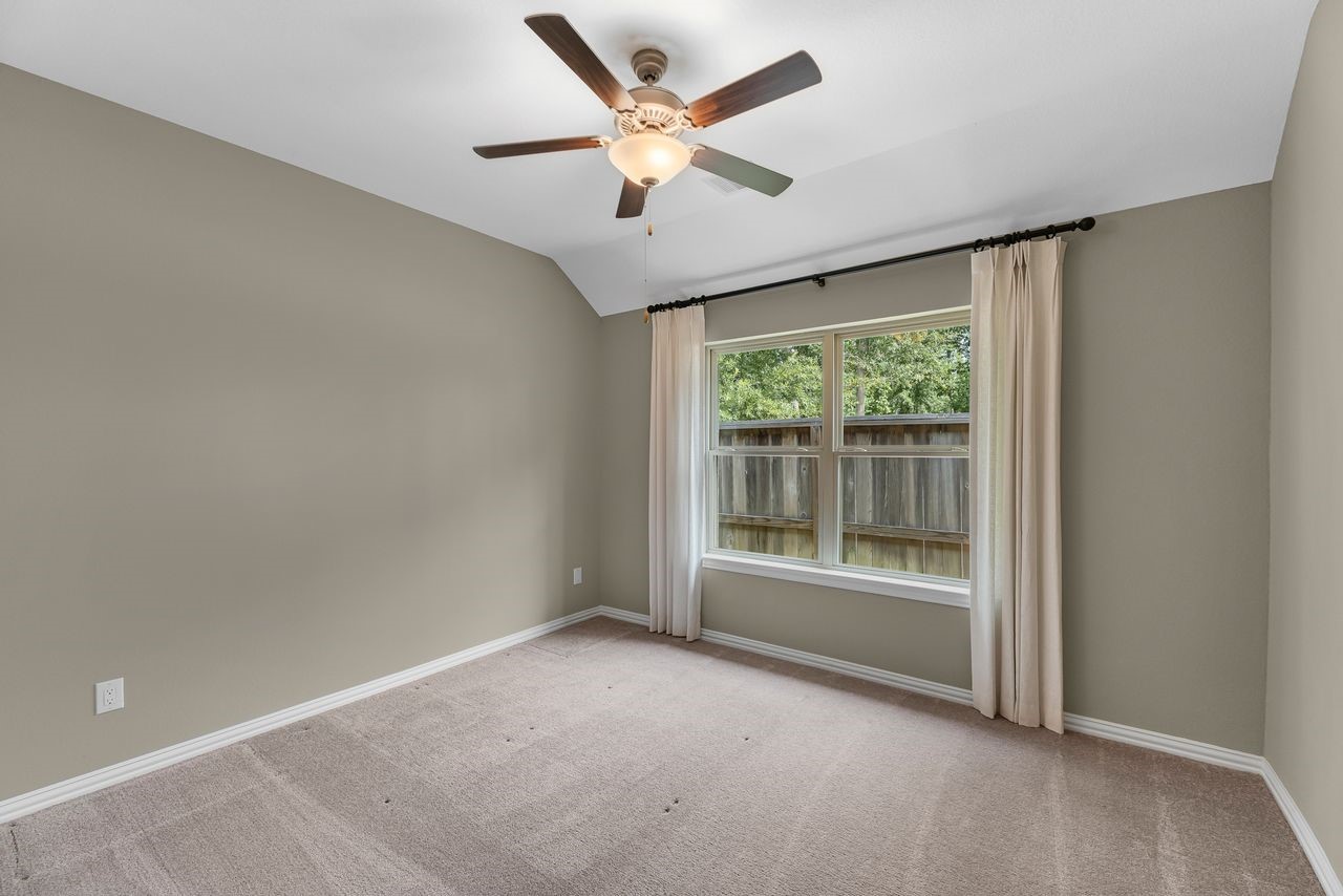 21714 Grayson Highlands Way Porter, TX 77365 - Photo 24 of 27 an empty room with a ceiling fan and a large window