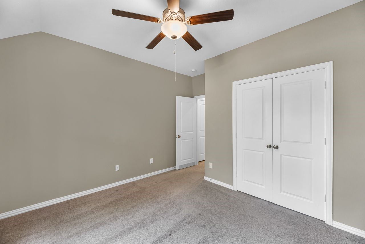 21714 Grayson Highlands Way Porter, TX 77365 - Photo 25 of 27 an empty room with closet and a chandelier fan