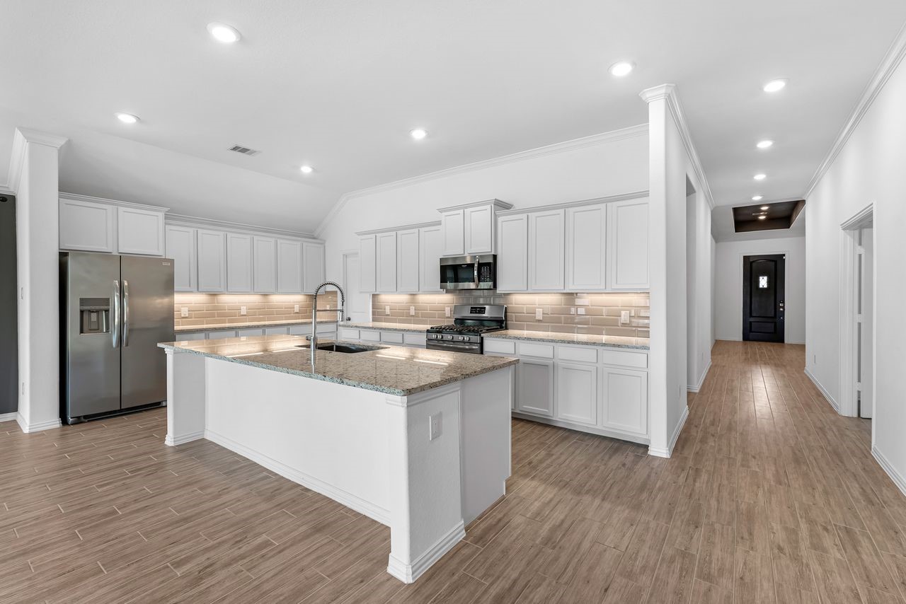 21714 Grayson Highlands Way Porter, TX 77365 - Photo 4 of 27 a kitchen with stainless steel appliances granite countertop a refrigerator oven a sink dishwasher and a stove with wooden floor
