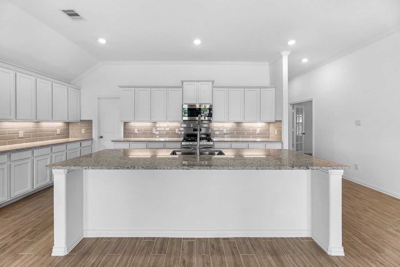 21714 Grayson Highlands Way Porter, TX 77365 - Photo 5 of 27 a kitchen with kitchen island granite countertop wooden cabinets and white stainless steel appliances