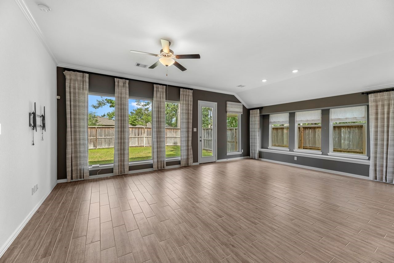 21714 Grayson Highlands Way Porter, TX 77365 - Photo 9 of 27 a view of an empty room with wooden floor and a window