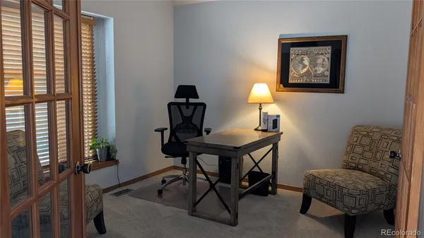 a view of a workspace with furniture and a window