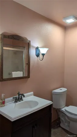 a bathroom with a toilet a sink and mirror