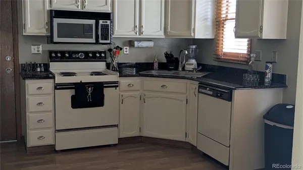 a kitchen with white cabinets and white appliances