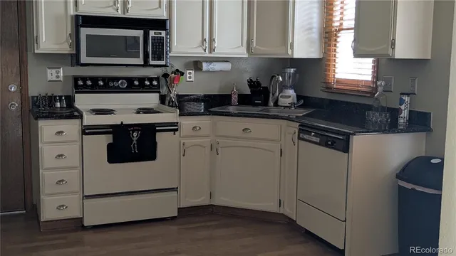 a kitchen with white cabinets and white appliances