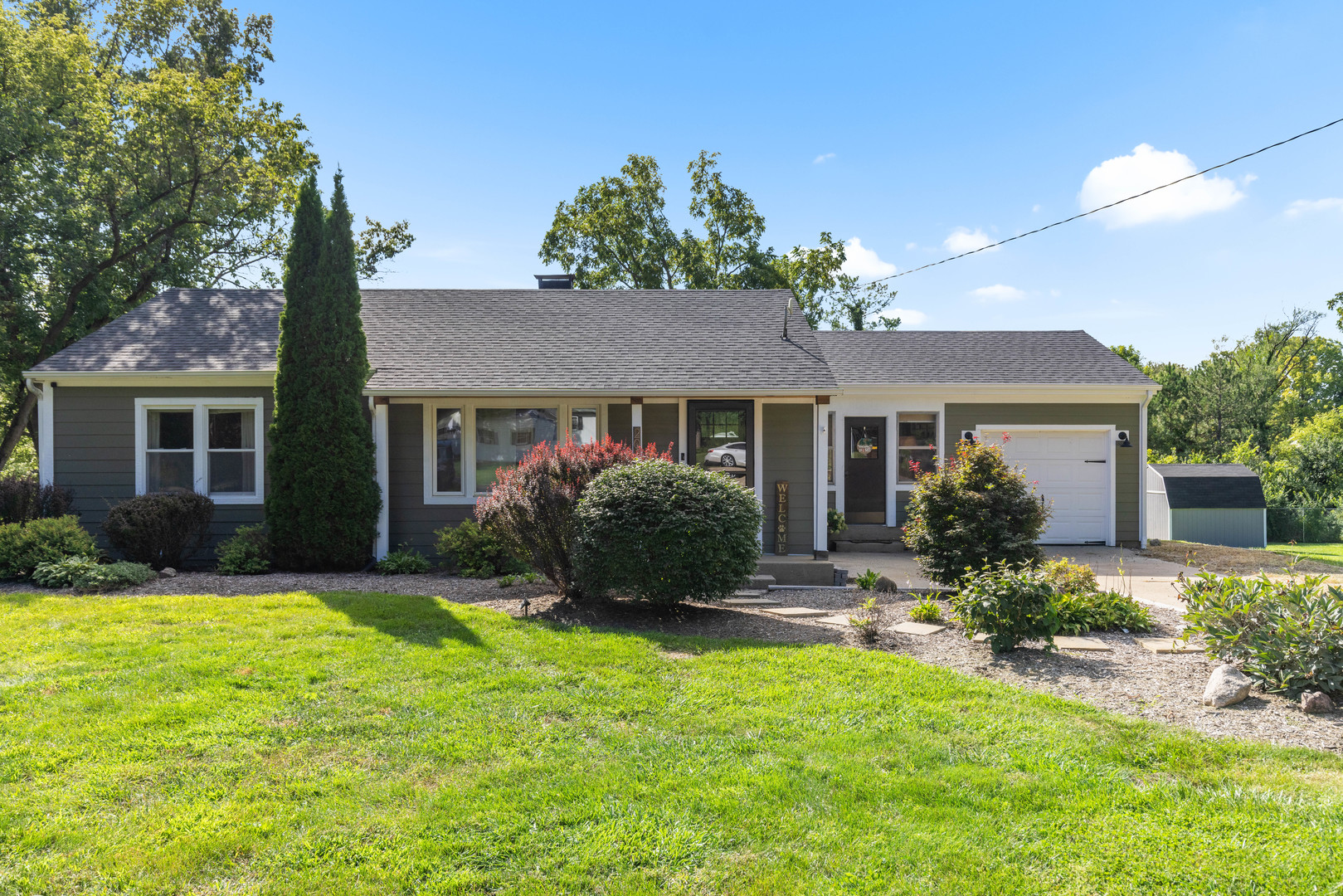 a front view of a house with a yard and outdoor seating