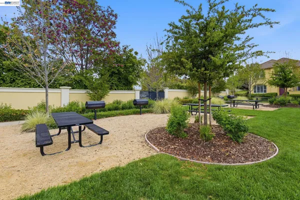 a swimming pool with outdoor seating and green space