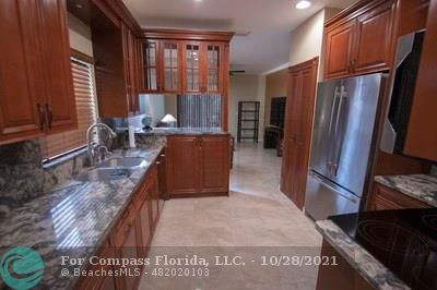 a large kitchen with stainless steel appliances granite countertop a refrigerator and a stove