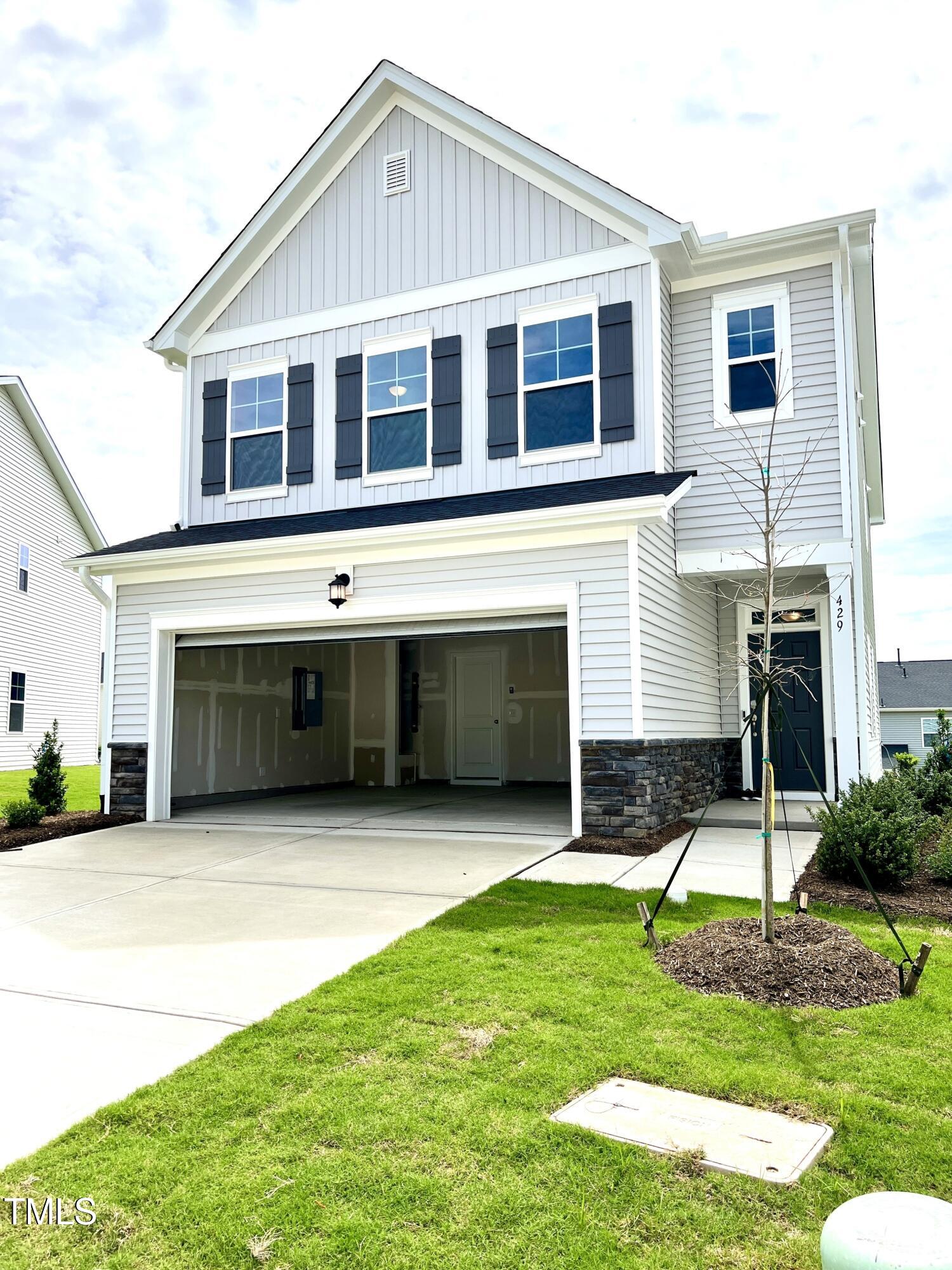 a front view of a house with a yard and garage
