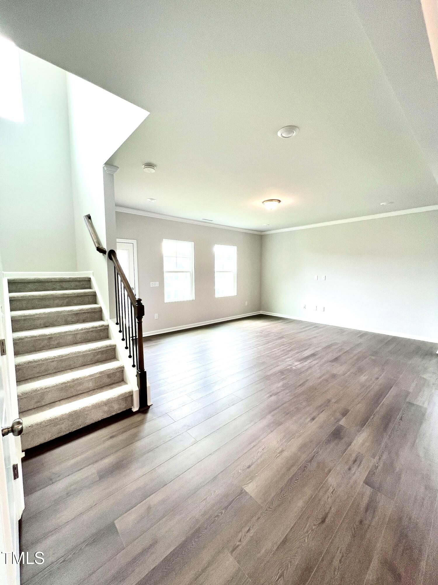 429 Lily Grv Loop Raleigh, NC 27610 - Photo 15 of 32 a view of an empty room with wooden floor and stairs
