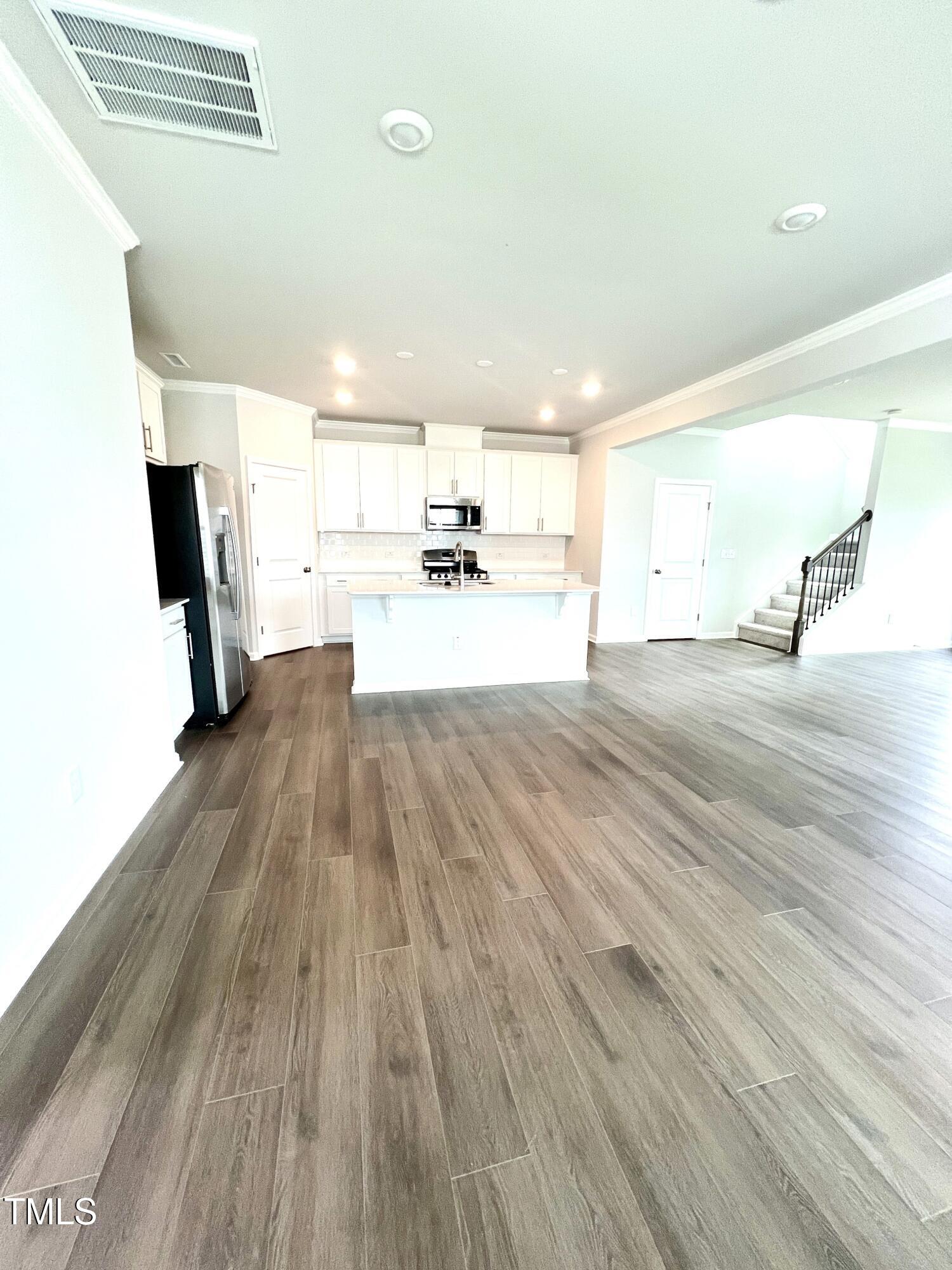 429 Lily Grv Loop Raleigh, NC 27610 - Photo 6 of 32 a view of a living room a kitchen with wooden floor