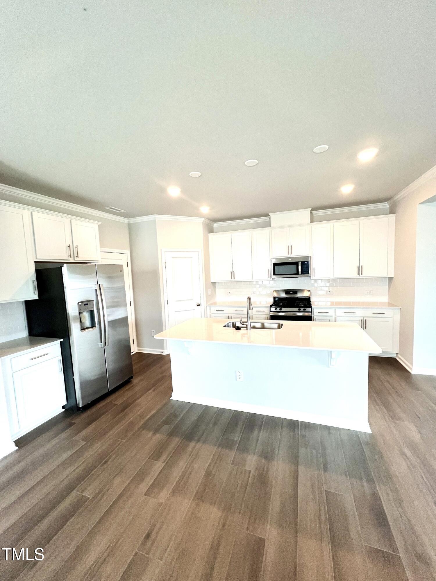 429 Lily Grv Loop Raleigh, NC 27610 - Photo 7 of 32 a view of kitchen with wooden floor and electronic appliances
