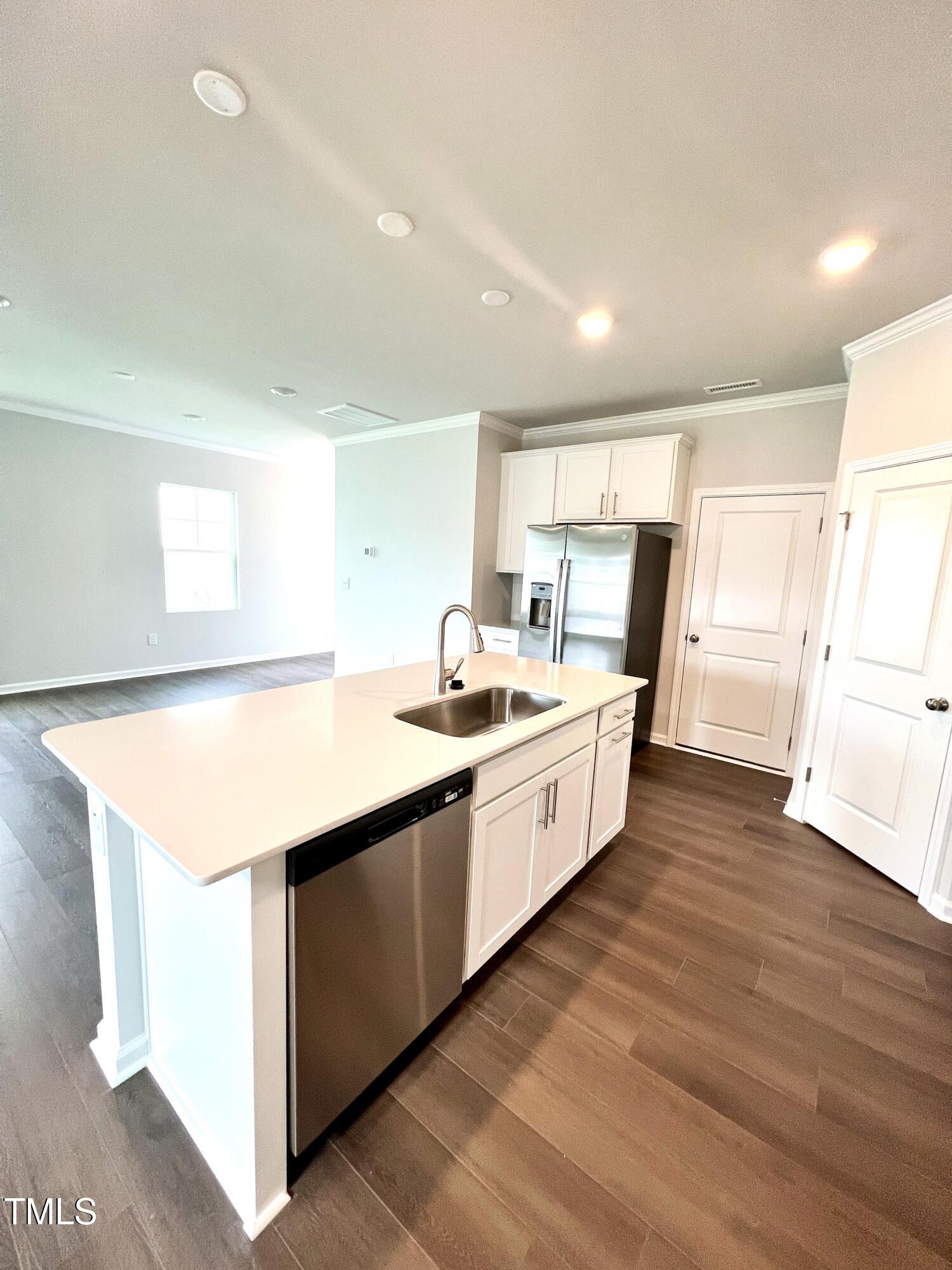 429 Lily Grv Loop Raleigh, NC 27610 - Photo 8 of 32 a large kitchen with kitchen island a sink dishwasher a refrigerator and a stove with wooden floor
