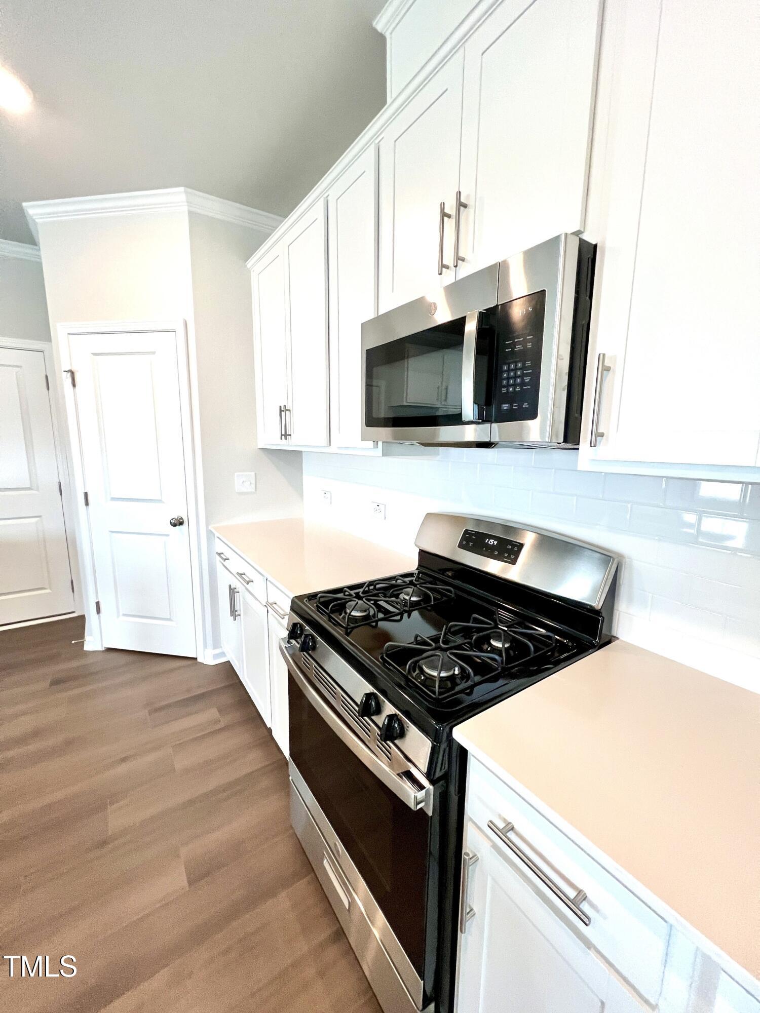 429 Lily Grv Loop Raleigh, NC 27610 - Photo 9 of 32 a kitchen with stainless steel appliances granite countertop a stove and a microwave