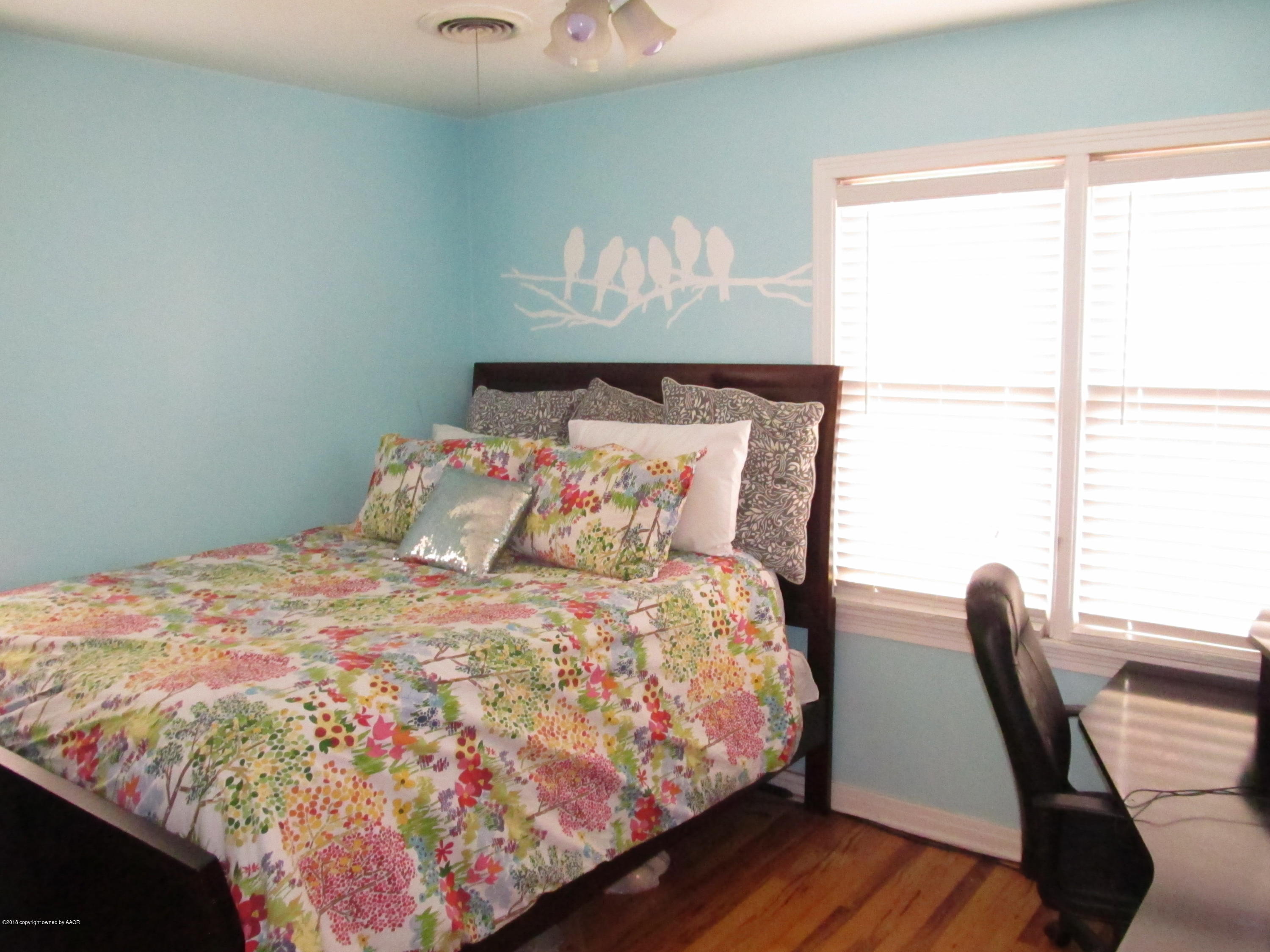 4215 South Jackson Street Amarillo, TX 79110 - Photo 6 of 8 a large bed sitting in a bedroom next to a window