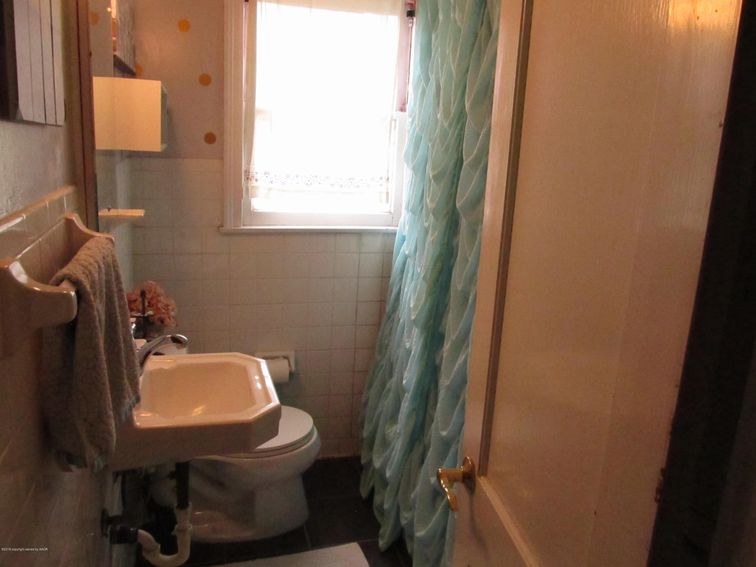 4215 South Jackson Street Amarillo, TX 79110 - Photo 7 of 8 a bathroom with a toilet sink and mirror