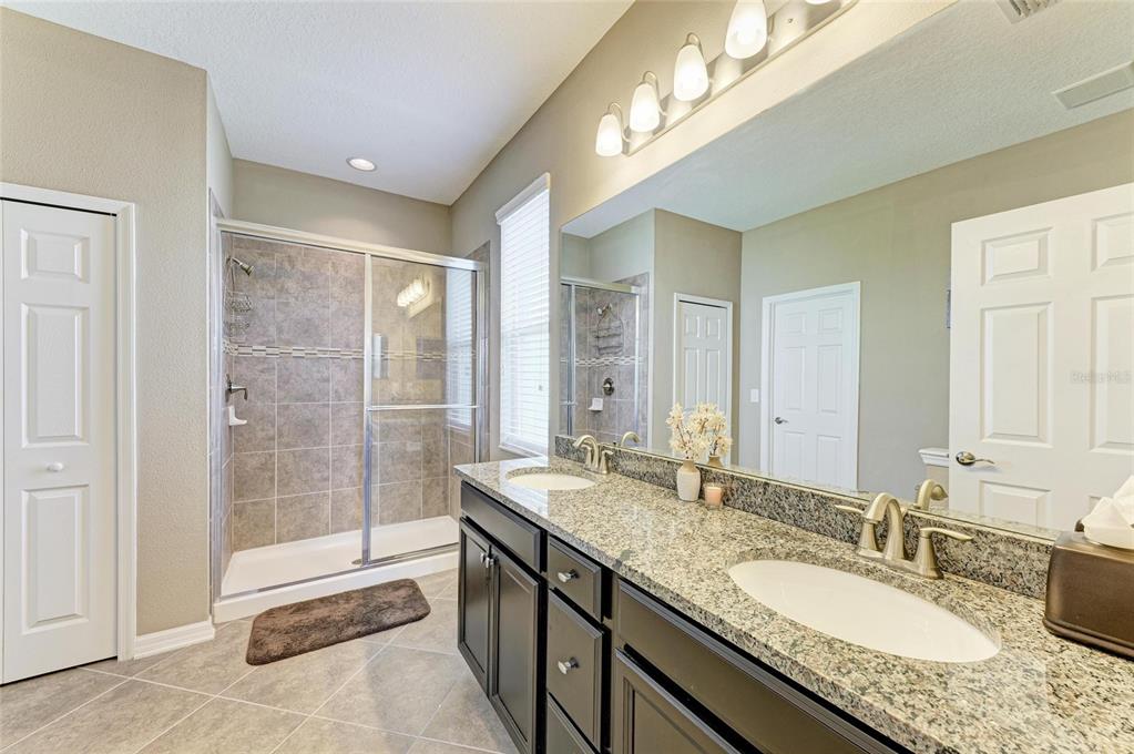 7926 111th Terrace East Parrish, FL 34219 - Photo 24 of 68 a bathroom with a granite countertop double vanity sink and a mirror