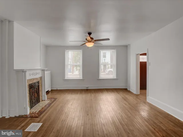 a view of empty room with wooden floor and fireplace