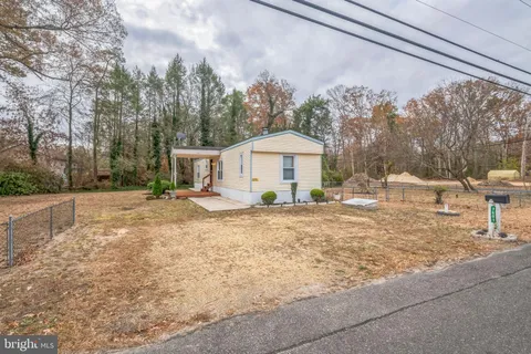 a view of a house with backyard and trees