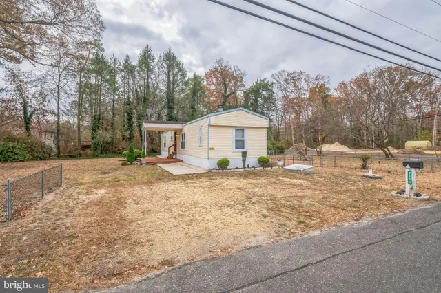 a view of a house with backyard and trees