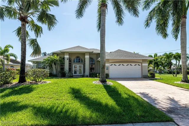a view of a house with a yard and palm trees