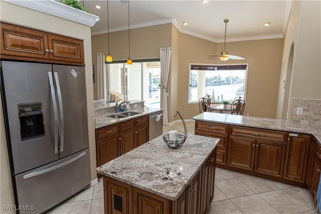a kitchen with stainless steel appliances granite countertop a refrigerator a sink a stove and a wooden floors
