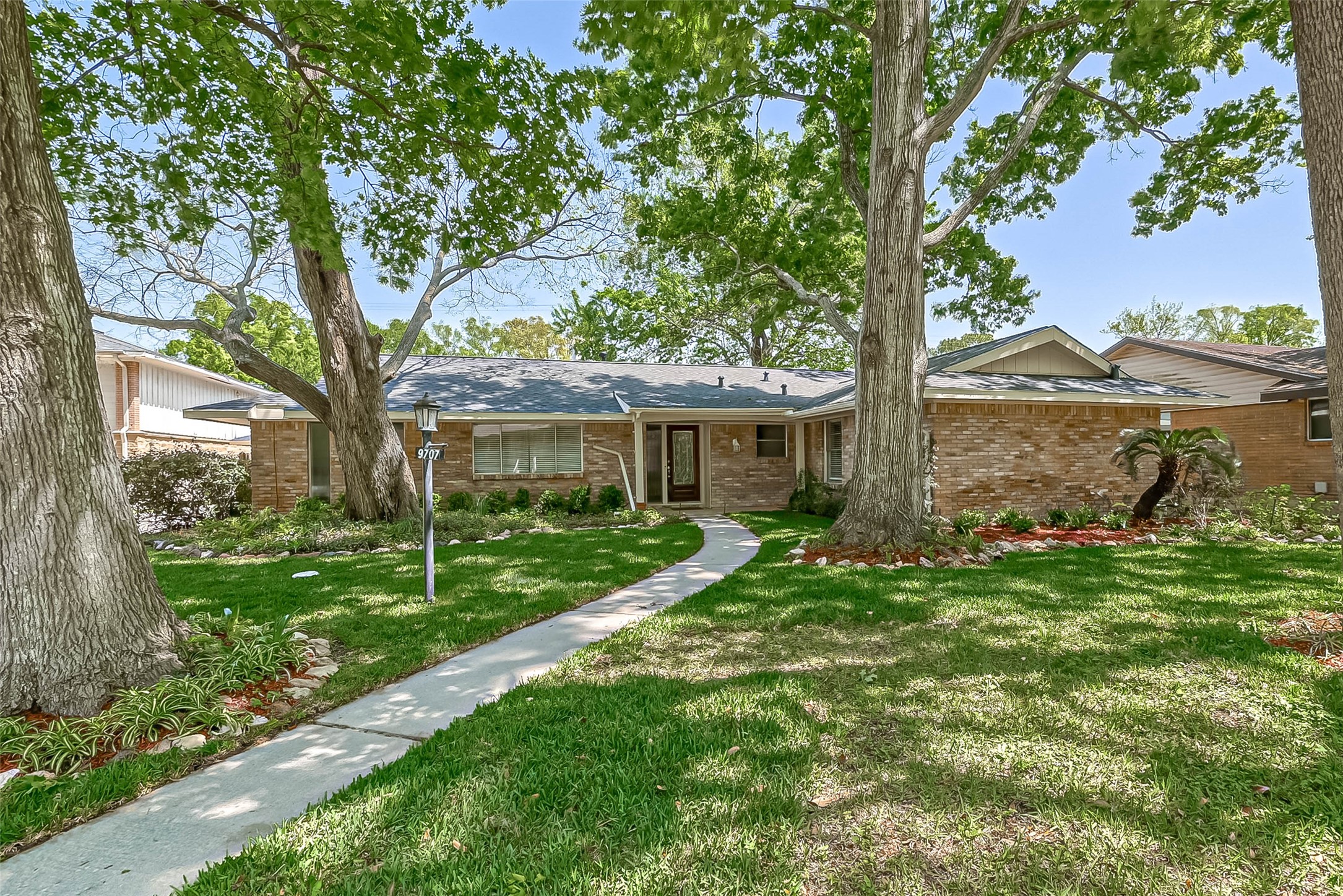 a front view of a house with a garden and yard