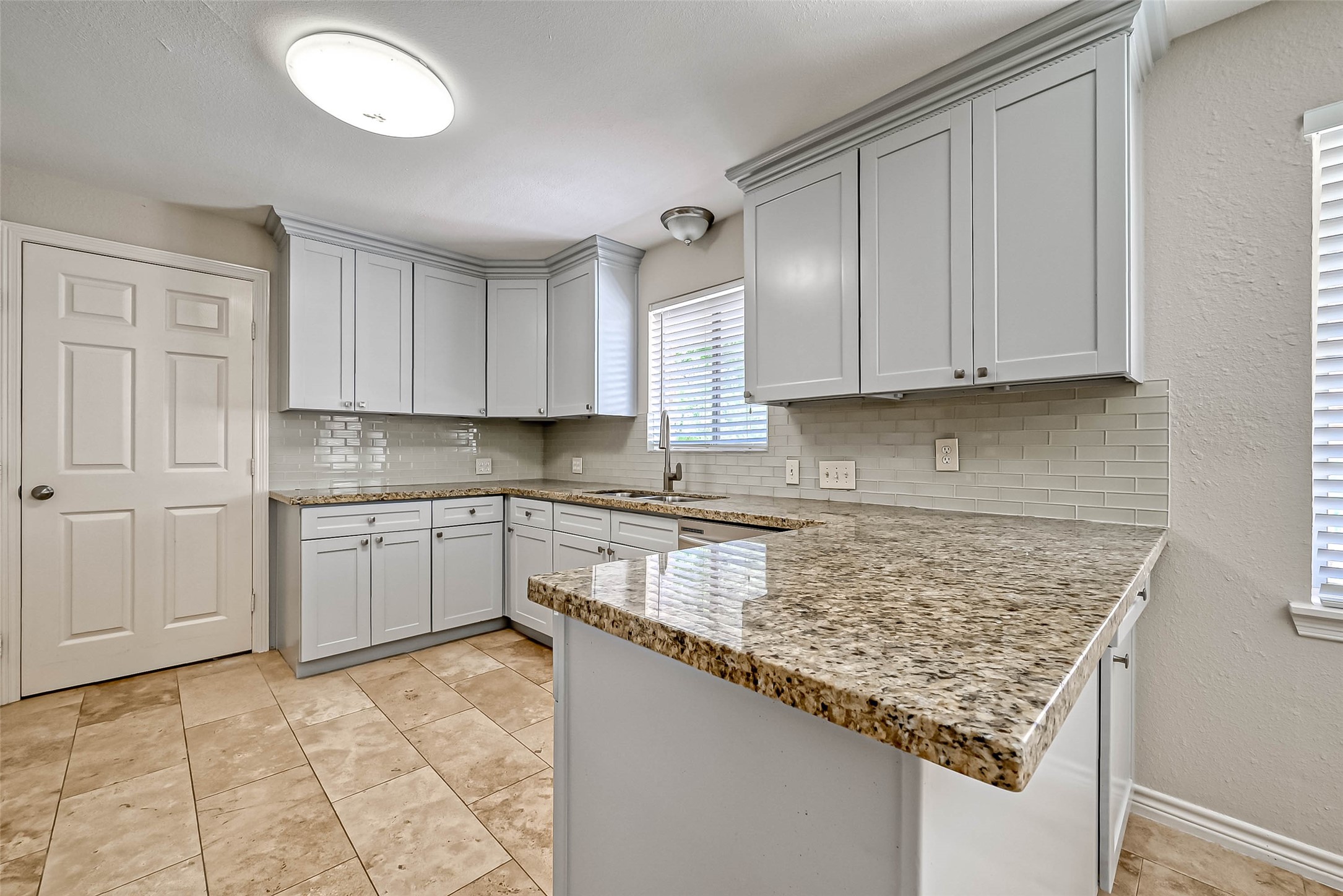 9707 Kit Street Houston, TX 77096 - Photo 13 of 45 a kitchen with granite countertop a sink stove and cabinets