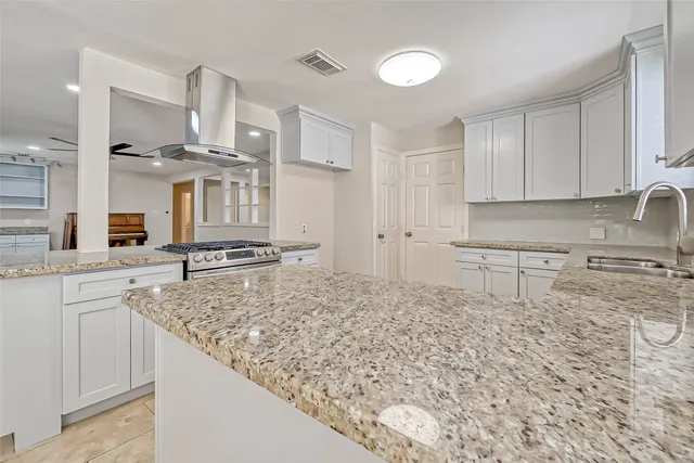 a kitchen with stainless steel appliances granite countertop a sink stove and cabinets