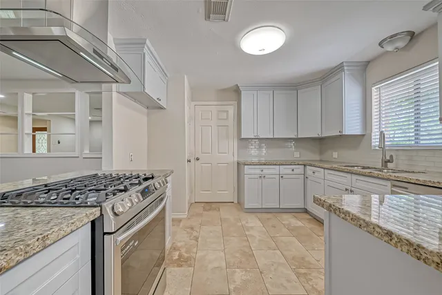 a kitchen with stainless steel appliances granite countertop a stove and a sink