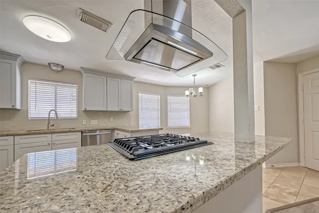 a bathroom with a granite countertop sink and a toilet