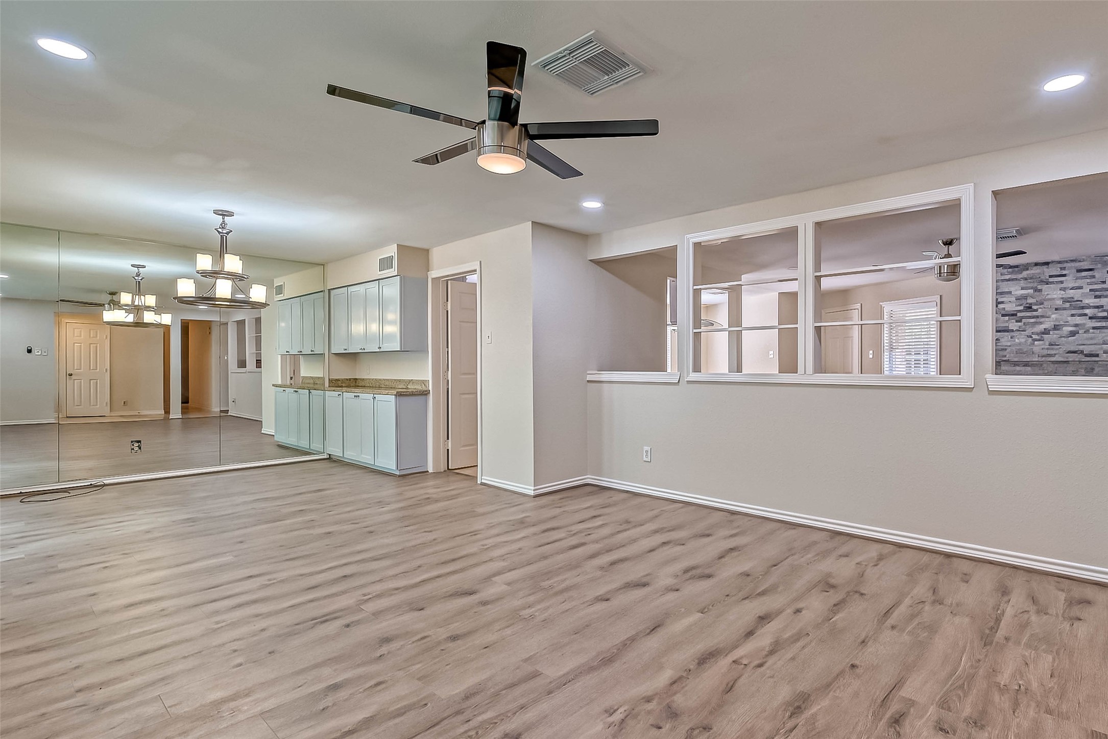9707 Kit Street Houston, TX 77096 - Photo 10 of 45 a view of an empty room with wooden floor and a kitchen