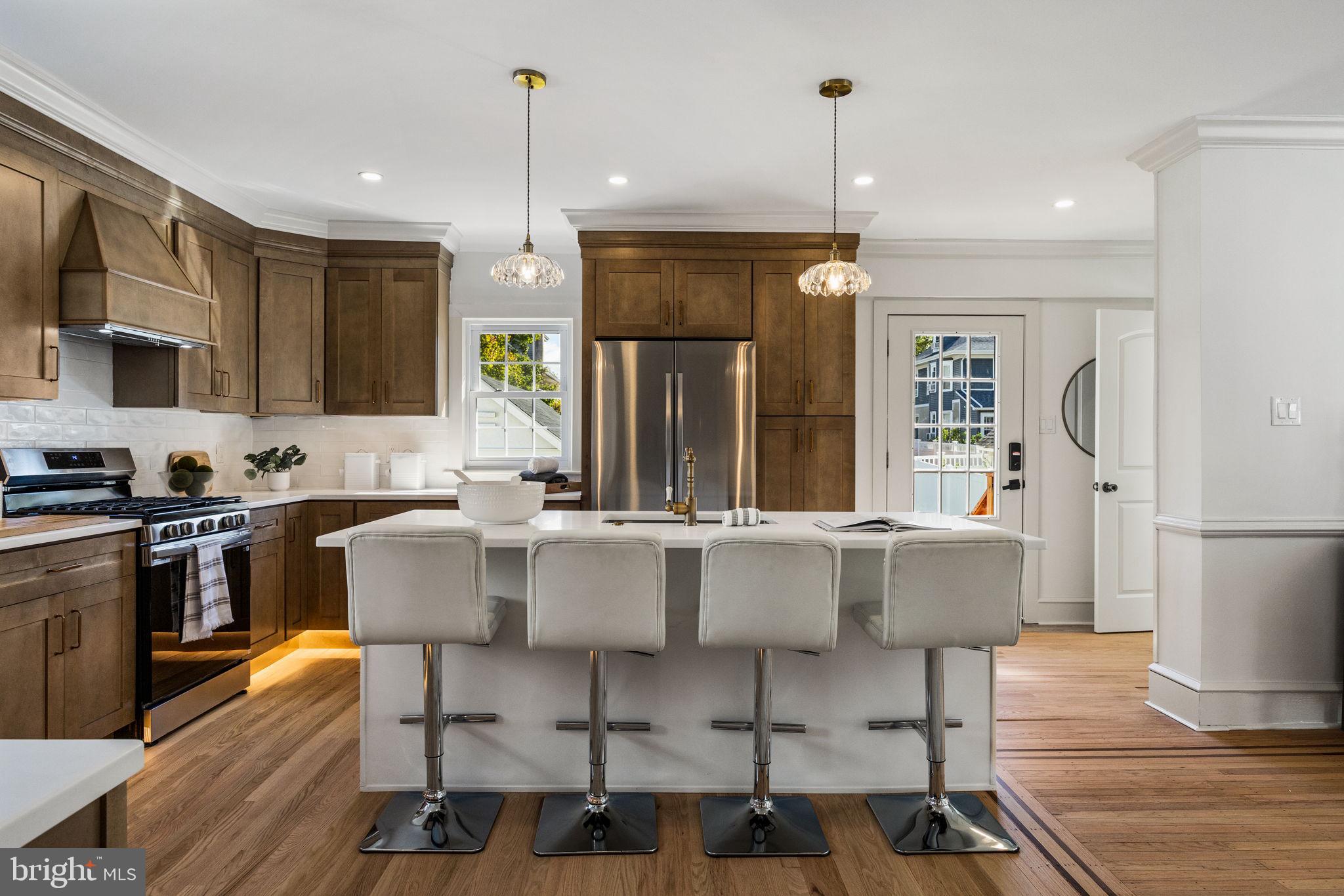 13 Princeton Road Havertown, PA 19083 - Photo 35 of 73 a kitchen with stainless steel appliances a dining table chairs stove refrigerator and cabinets
