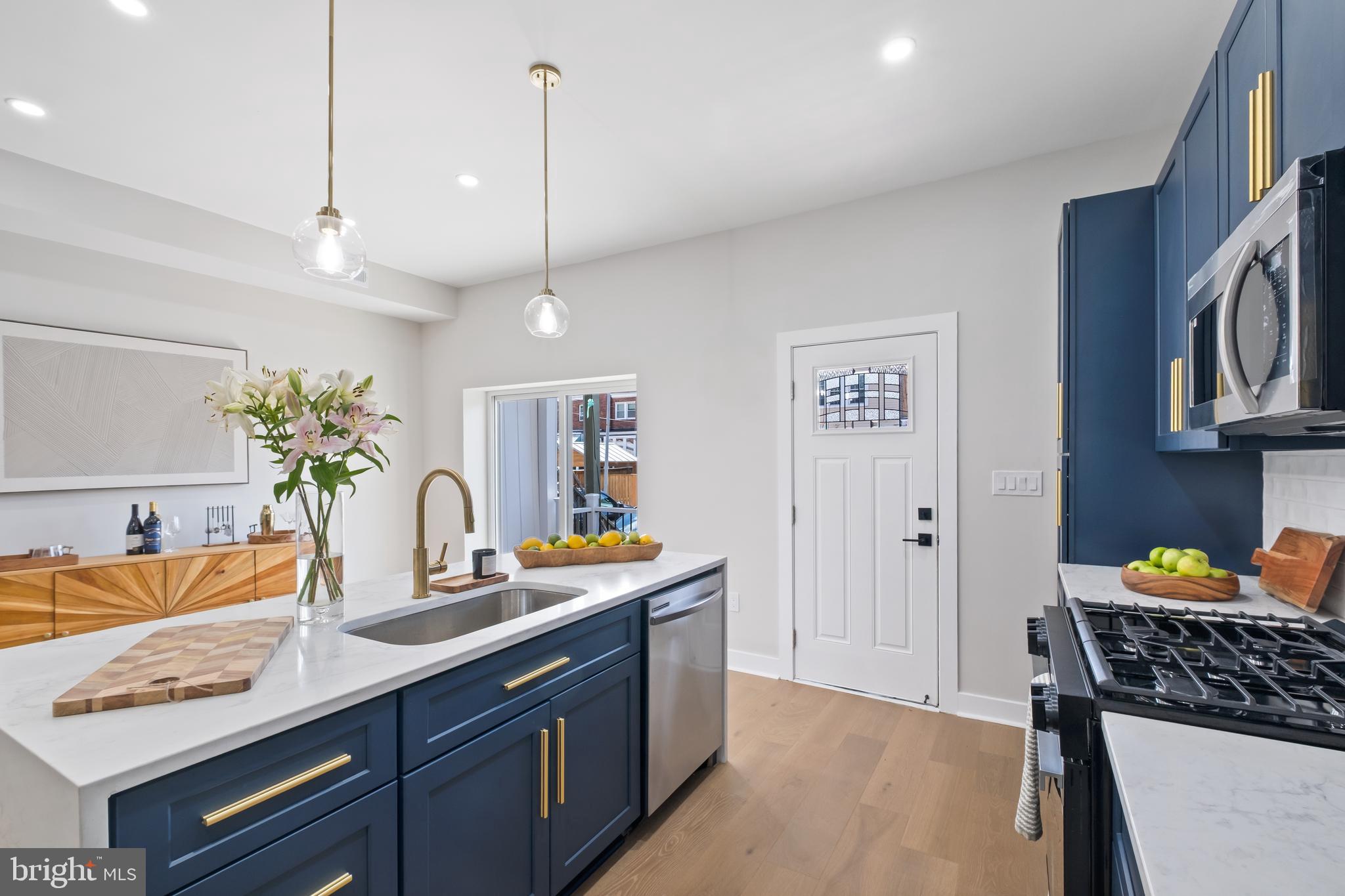 35 Michigan Avenue Northeast Washington, DC 20002 - Photo 5 of 28 a kitchen with stainless steel appliances granite countertop a sink dishwasher with a dining table and chairs with wooden floor