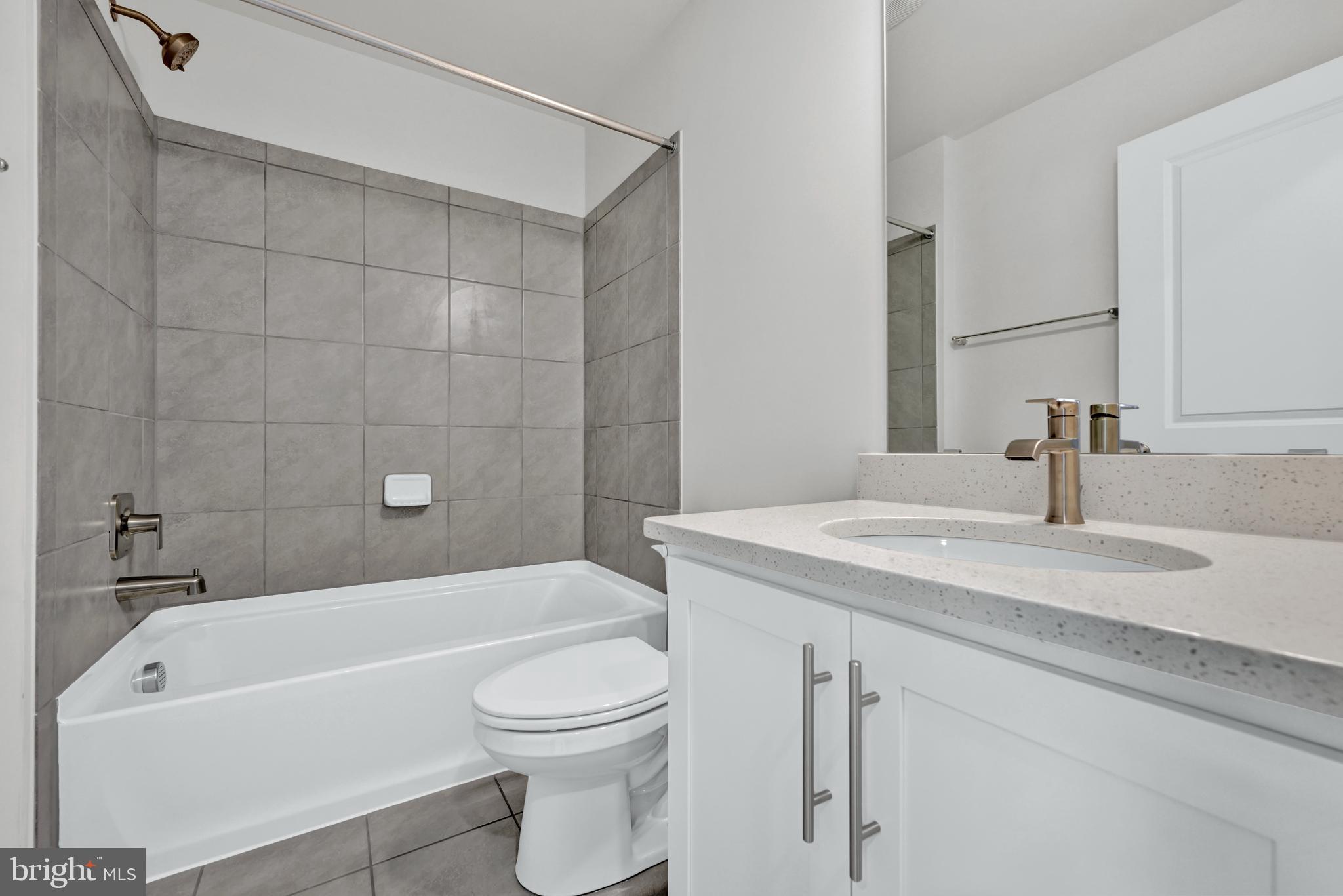 32 Merion Avenue Baltimore, MD 21237 - Photo 14 of 24 a bathroom with a granite countertop bathtub shower sink vanity mirror and toilet