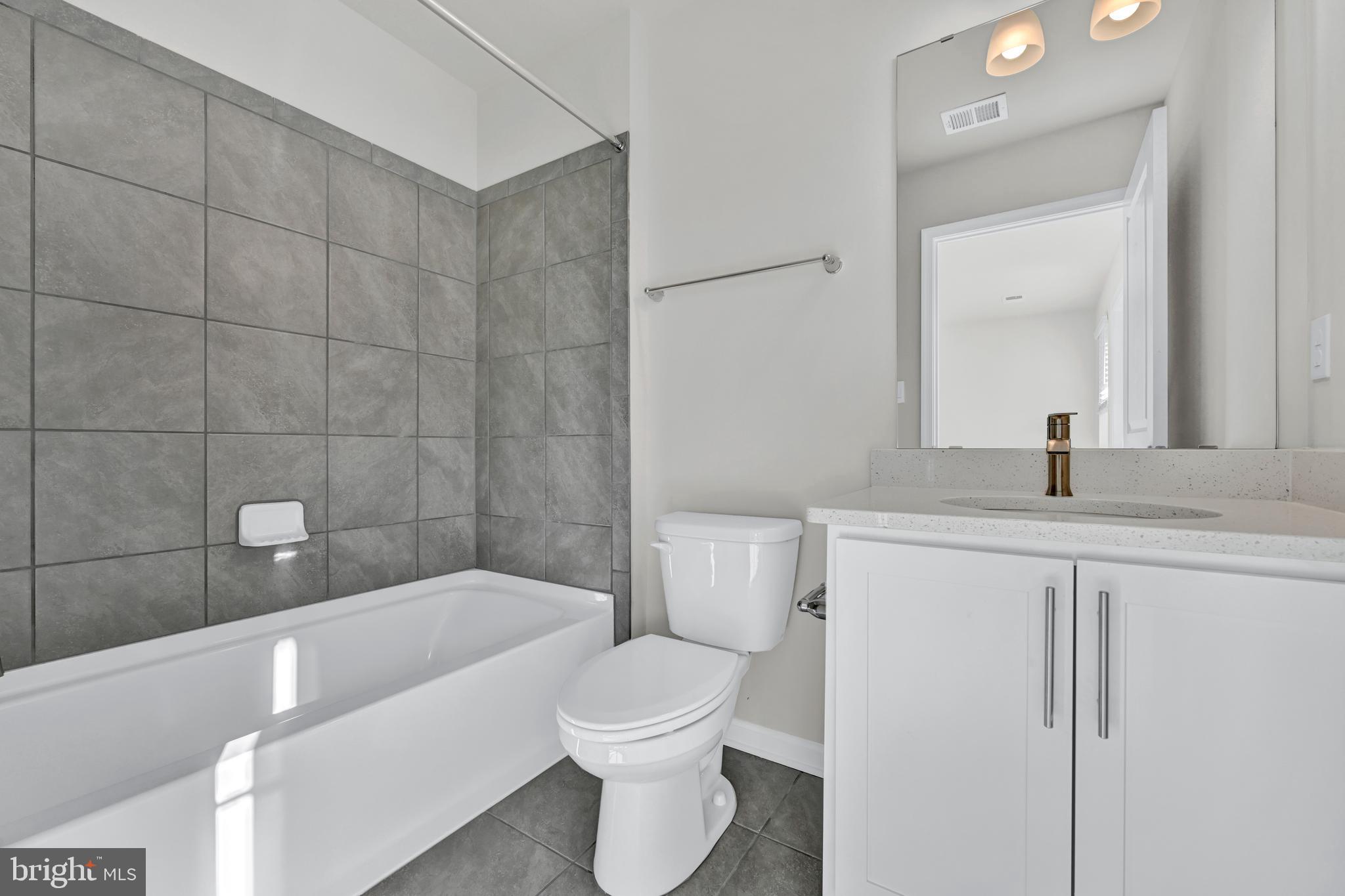 32 Merion Avenue Baltimore, MD 21237 - Photo 23 of 24 a bathroom with a bathtub a sink a toilet and a mirror
