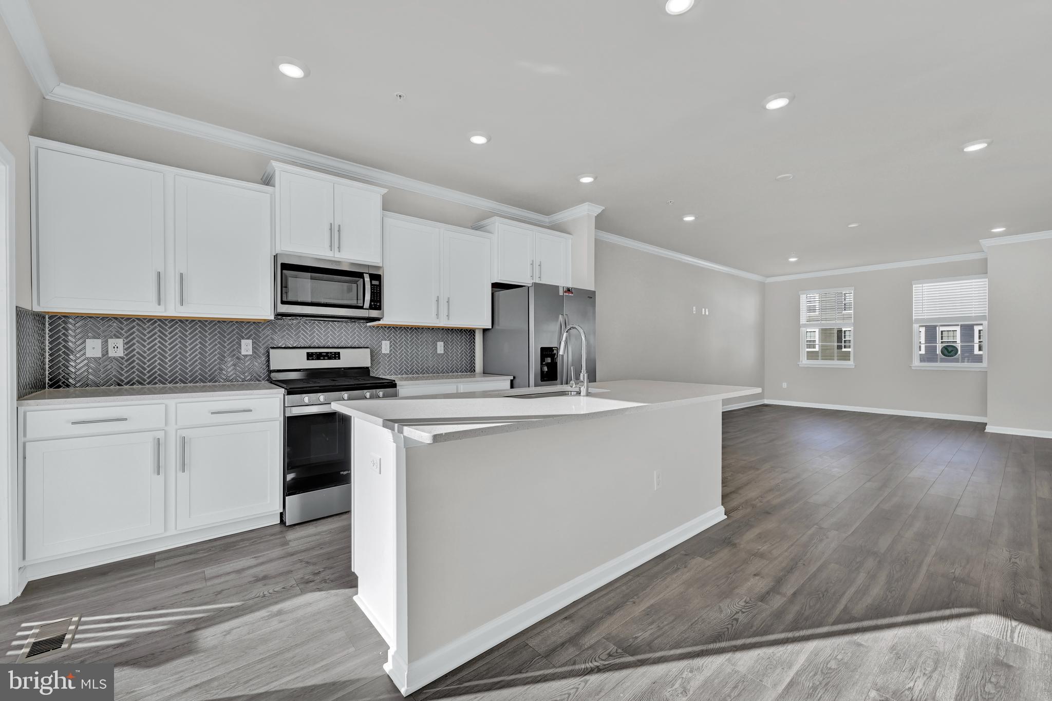 32 Merion Avenue Baltimore, MD 21237 - Photo 8 of 24 a kitchen with stainless steel appliances a sink a stove a microwave a center island and cabinets