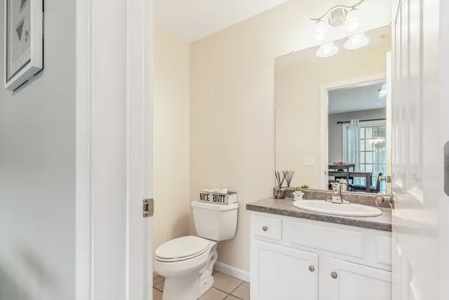 a bathroom with a granite countertop sink toilet and a mirror