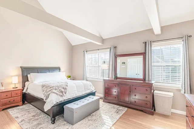 a bedroom with a large bed and windows