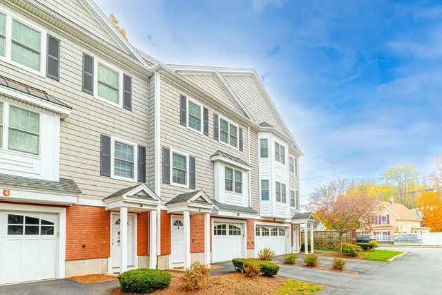 a front view of a residential apartment building with a yard