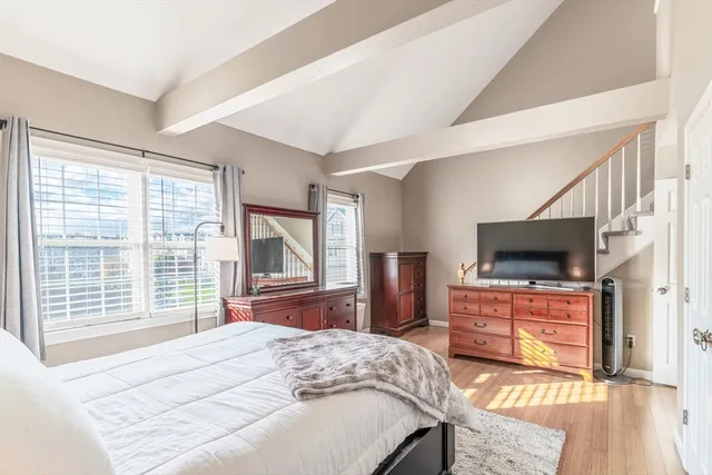a bedroom with a bed and a flat screen tv on dresser
