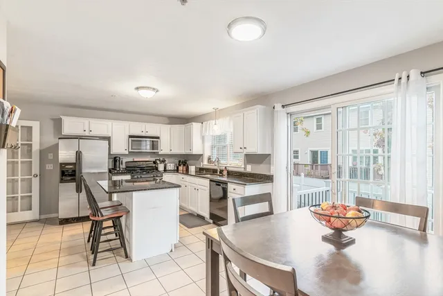 a kitchen with stainless steel appliances kitchen island granite countertop a table and chairs