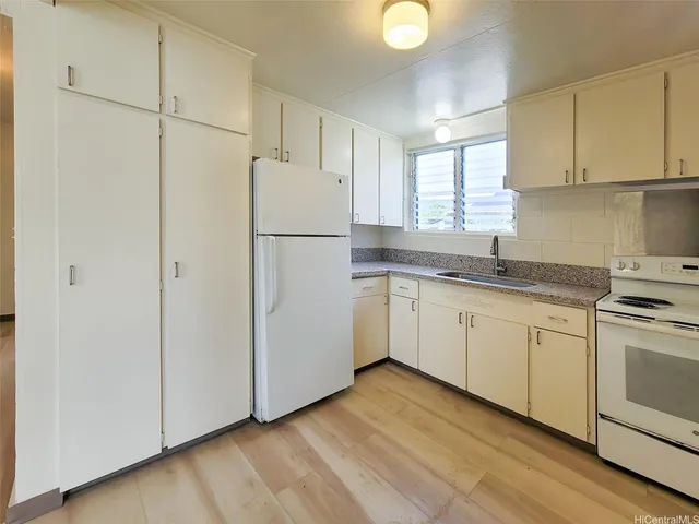 a kitchen with cabinets appliances a sink and a window