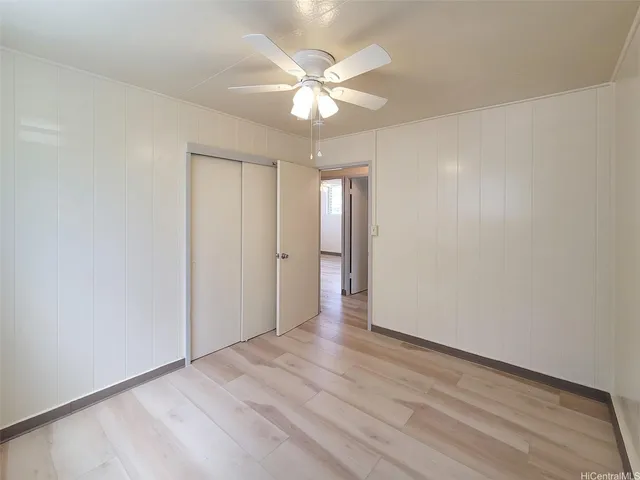 a view of an empty room with a ceiling fan