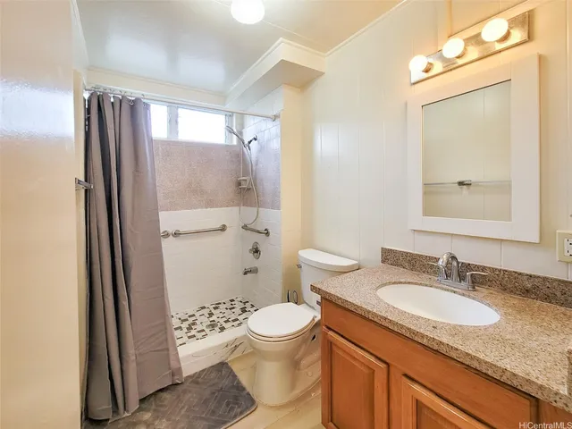 a bathroom with a granite countertop sink toilet and shower