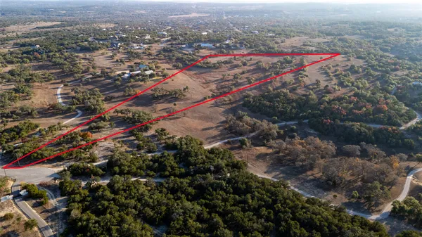 an aerial view of a houses with a street and trees