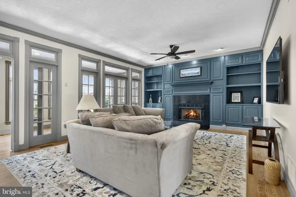 a kitchen with stainless steel appliances kitchen island granite countertop a refrigerator a stove and a wooden cabinets with wooden floor